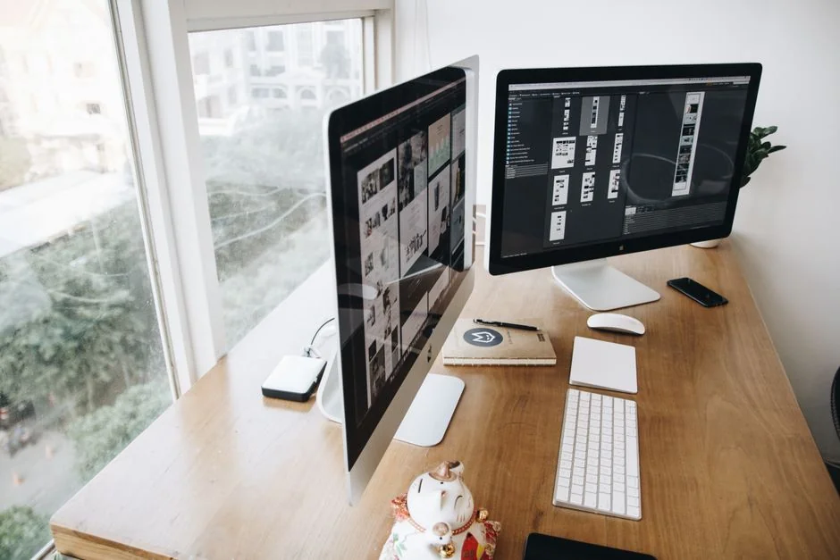 A contemporary workspace featuring a smartphone showing a display alongside a computer setup, well suited to business and technology themes.